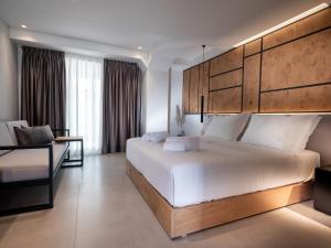 a bedroom with a large white bed and a couch at Sigma59 Dine & Stay in Hersonissos +6 photos