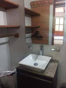 y baño con lavabo blanco y espejo. en Refugio Villa Emilio, en Villa de Leyva