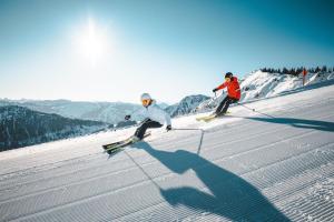 韋斯滕多夫的住宿－Appartement Morgensonne，两个人在雪覆盖的斜坡上滑雪
