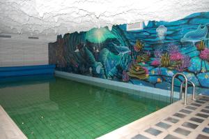 a swimming pool with a mural of an aquarium at Hotel Friesengeist in Wiesmoor
