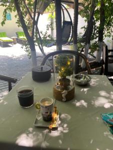 uma mesa verde com uma vela e copos sobre ela em Hugo's House em Costinesti