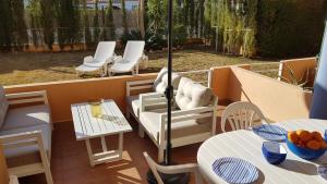 een balkon met witte meubels en tafels en stoelen bij El Velero in Balcon del Mar