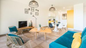 ein Wohnzimmer mit einem blauen Sofa und Stühlen in der Unterkunft Les Bulles avec Jacuzzi Privatif & Parking privé in Sarlat-la-Canéda