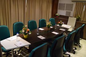 a conference room with a long table and chairs at Thiviyam Airport Hotel in Chennai