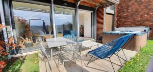 eine Terrasse mit Stühlen, einem Tisch und einer Bar in der Unterkunft Les Bulles avec Jacuzzi Privatif & Parking privé in Sarlat-la-Canéda