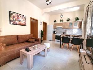 Una sala de estar con un sofá y una mesa y una cocina. en Alex Apartment, Cozy Place in Heraklion Center, en Heraclión