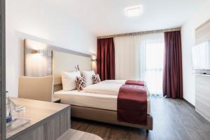 a hotel room with two beds and a large window at Abasto Hotel München Feldmoching in Munich