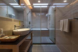 un bagno con lavandino e doccia in vetro di 花蓮晨風星語民宿Sun Star B&B a Ji'an Altre 37 foto