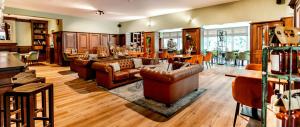 a living room with leather furniture and a dining room at Hotel Herikerberg in Markelo