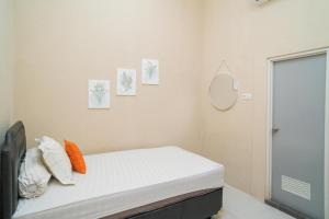 a bedroom with a bed with pillows and a mirror at Koolkost Syariah near Jalan Ahmad Yani Banjarmasin in Sungai Lutus