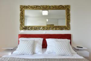 espejo sobre una cama con almohadas blancas en MM Luxury Apartments GOLD & RUBIN, en Zadar