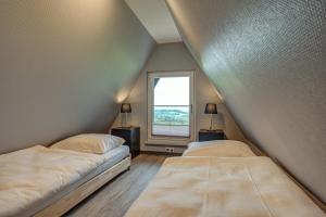 dwa łóżka w pokoju z oknem w obiekcie Ferienhaus Hohe Klinge w mieście Brotterode