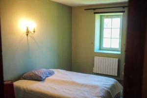 a bedroom with a bed with a light on the wall at Maison spacieuse proche du centre de Landevieille + jardin clôturé in Landevieille +6 photos