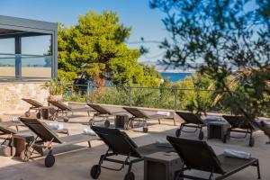 a row of chairs and tables on a patio at Hotel Osam - Adults Only in Supetar