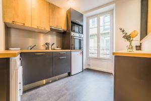 eine Küche mit Küchengeräten aus Edelstahl und einem Fenster in der Unterkunft LESTANG #2 - Appartement Contemporain - 1 Chambre in Brive-la-Gaillarde