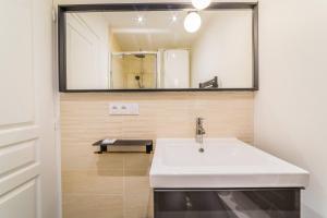 a bathroom with a sink and a mirror at Le Contemporain - 1 Chambre in Brive-la-Gaillarde