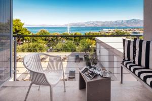 a balcony with a table and a chair and the ocean at Hotel Osam - Adults Only in Supetar