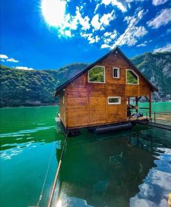 uma casa sobre a água em um lago em kucica na vodi drinski snovi em Mali Zvornik