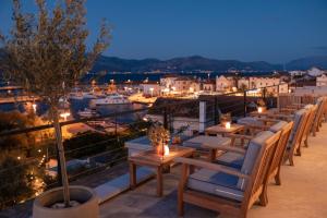 a row of tables and chairs on a balcony at night at Hotel Osam - Adults Only in Supetar