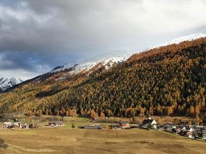 einen schneebedeckten Berg mit einem Dorf vor einem Berg in der Unterkunft Chalet Breithorn- Perfect for Holiday with Amazing View! in Obergesteln
