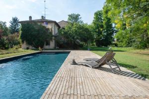 einen Pool mit zwei Stühlen neben einem Haus in der Unterkunft Splendido apt con piscina e parking a Colorno in Colorno