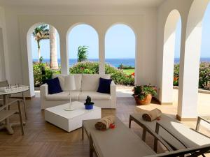a living room with a couch and tables and the ocean at Royal Palm Resort & Spa - Adults Only in Playa Jandia