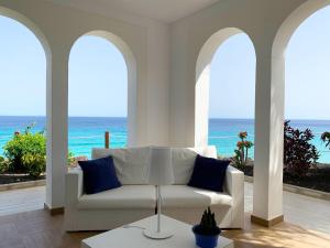 a living room with a white couch and the ocean at Royal Palm Resort & Spa - Adults Only in Playa Jandia