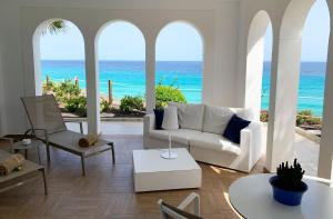 a living room with a white couch and the ocean at Royal Palm Resort & Spa - Adults Only in Playa Jandia