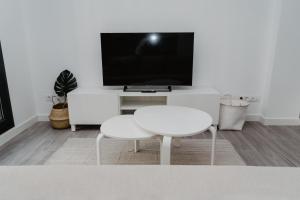 a living room with a white table and a tv at Charming loft next to wonders of Cordoba in Córdoba