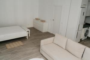 a white living room with a couch and a bed at Charming loft next to wonders of Cordoba in Córdoba