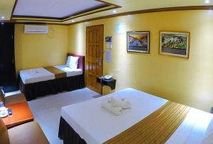 a hotel room with two beds and towels at RedDoorz Plus @ Taj Hotel Tuguegarao in Tuguegarao City