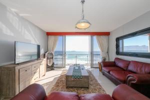 a living room with a couch and a flat screen tv at Infinity 602 in Bloubergstrand