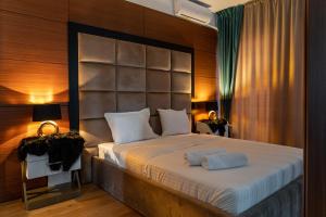 ブカレストにあるNorthApartmentsの大きなヘッドボード付きの大きなベッドのある寝室