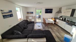 a living room with a large couch and a kitchen at Ferienhaus in Kuehlungsborn in Kühlungsborn +23 photos