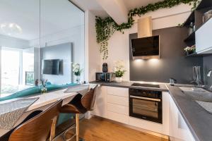 ブカレストにあるNorthApartmentsの白いキャビネットとカウンタートップを備えたキッチン