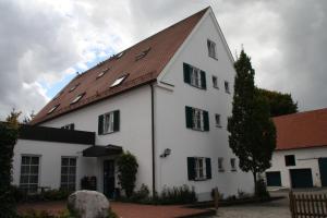 ein großes weißes Gebäude mit braunem Dach in der Unterkunft Hotel Gasthaus Wangerhof in Augsburg