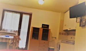 a kitchen with a window and a television on a wall at Il nido di Asia CIR N0310 in Breuil-Cervinia
