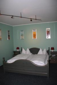 Schlafzimmer mit einem Bett mit weißer Bettwäsche und Kissen in der Unterkunft Hotel Gasthaus Wangerhof in Augsburg