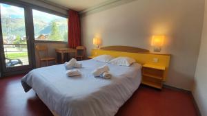 a hotel room with a bed with towels on it at Village vacances de Val d'Isère in Val-d'Isère