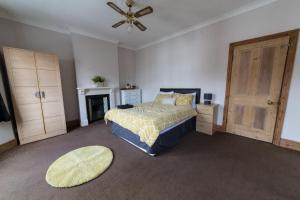 Schlafzimmer mit einem Bett und einem Deckenventilator in der Unterkunft High spec team accommodation w. Super fast wifi in Bedford