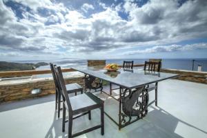 a table and chairs on a balcony with a view of the ocean at The house of the setting sun in Apróvaton