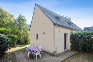 Una mesa y sillas frente a un edificio. en Appartement confortable avec terrasse à Arzon - 60 m², en Arzon