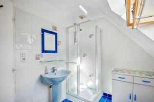Un baño blanco con lavabo y ducha. en Appartement confortable avec terrasse à Arzon - 60 m², en Arzon