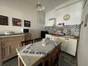 uma cozinha com mesa e cadeiras e uma cozinha com balcão em Back to the past em Olbia