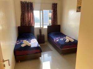 a bedroom with two beds and a window at Appartment Anjou in Casablanca