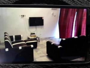 sala de estar con sofás y cortina roja en 109 Tanjung Gemuk, en Port Dickson
