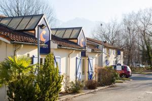 una fila de casas con una furgoneta roja estacionada frente a ellos en Comfort Hotel Grenoble Meylan, en Meylan