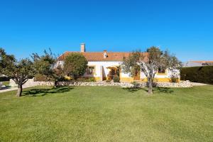 uma casa com um quintal com árvores em frente em Monte do Tanoeiro - Casa Tonel em Rogil