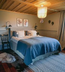 1 dormitorio con 1 cama grande con manta azul en Fryksas Chalet, en Fryksås