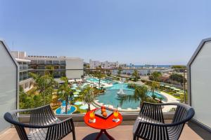 a balcony with two chairs and a swimming pool at Faros Hotel Ayia Napa in Ayia Napa